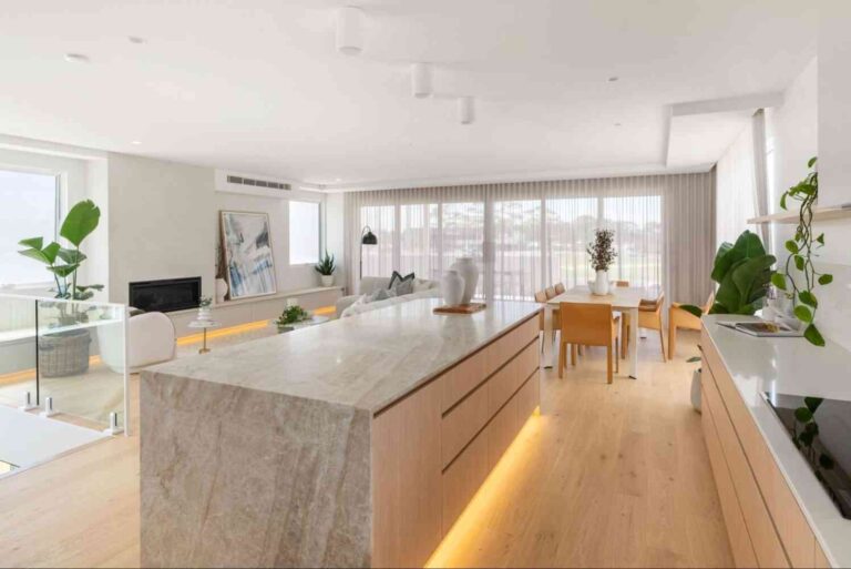 a-large-white-natural-stone-kitchen-island-with-golden-light-underground