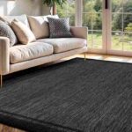 cozy-living-room-features-a-modern-light-gray-sofa-with-various-pillows-and-large-rectangular-area-rug-covers-the-floor