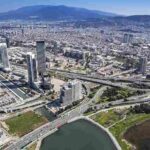 high-rise-building-a-river-body-of-water-winding-through-the-urban-area-and-complex-road-system-and-bridges