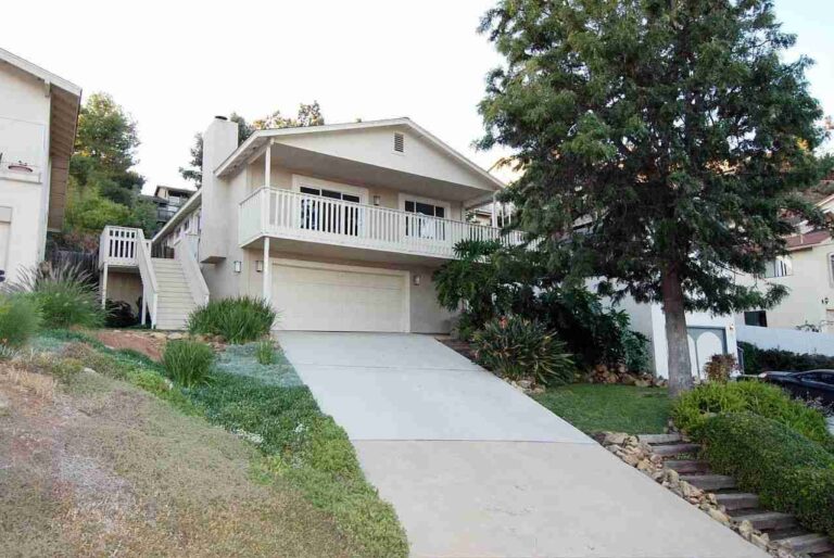 Understanding MLS Listings: What They Reveal Beyond Basic Property Details house-with-white-exterior-with-two-car-garage-on-lower-level-and-balcony-accessible-from-the-upper-floor