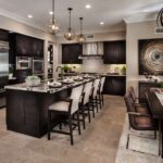 kitchen-features-dark-wood-cabinetry-and-light-colored-marble-countertops-and-large-island-in-the-center