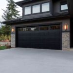 the-front-exterior-of-a-modern-house-and-a-black-garage-door-the-home-has-a-design-with-clean-lines-neutral-colors-and-mix-of-material
