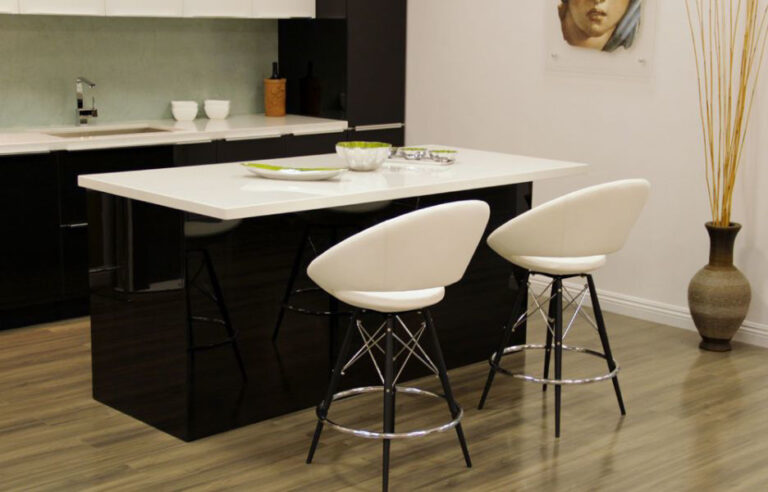 white-kitchen-island-with-a-sleek-black-base-is-placed-at-the-center-and-two-white-bar-stools-with-metal-legs-are-neatly-arranged-beside-the-island
