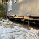 white-protective-sheet-or-tarp-laid-over-the-ground-covering-some-construction-materials-and-dirt