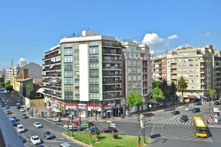 Unlocking Growth: Real Estate in Spain Offers Strategic Investment Avenues a-city-with-modern-multi-story-apartment-building-several-cars-are-driving-on-the-road
