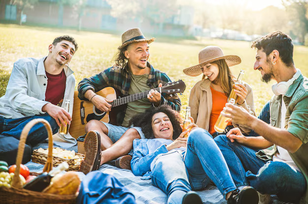 The Meaningful Purchases People Are Prioritising in Their 30s a-group-of-young-friends-enjoying-a-picnic-together-in-a-park-they-are-sitting-on-a-blanket-on-the-grass-in-an-open-outdoor-area