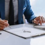 a-person-dressed-in-formals-and-writing-or-taking-notes-with-a-pen-on-paperwork