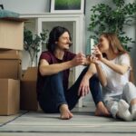 boy-and-girl-sitting-on-floor-of-a-new-home-surrounded-by-packed-cardboad-boxes-and-they-just-moved-in