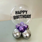 clear-round-ballon-with-the-text-happy-birthday-printed-in-black-capital-letters