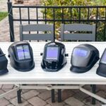 five-different-welding-helmet-placed-side-by-side-on-a-light-colored-outdoor-table