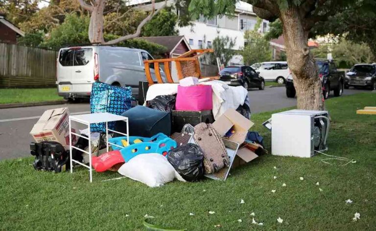 Curb Appeal Overhaul: Why Spring Is the Perfect Time to Rent a Roll-Off Dumpster large-accumulation-of-assorted-household-waste-and-bulky-items-placed-on-a-grassy-verge-next-to-a-residential-street