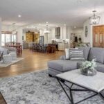 luxury-living-room-with-a-light-gray-sectional-sofa-with-pillows-and-modern-square-coffee-table-and-hardwood-flooring