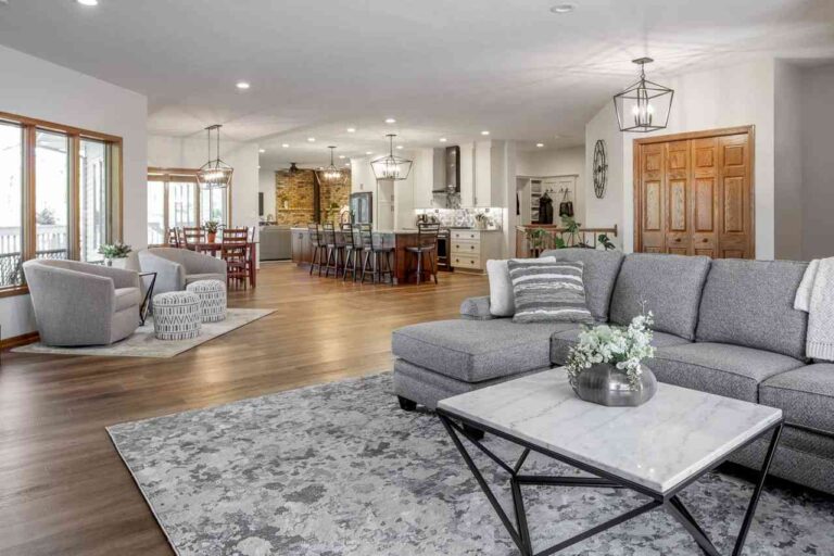 luxury-living-room-with-a-light-gray-sectional-sofa-with-pillows-and-modern-square-coffee-table-and-hardwood-flooring