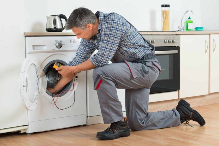male-appliance-repair-technician-actively-working-on-a-white-front-loading-washing-machine
