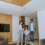 modern-living-room-interior-with-warm-design-and-a-family-of-three-walking-together-inside-the-space