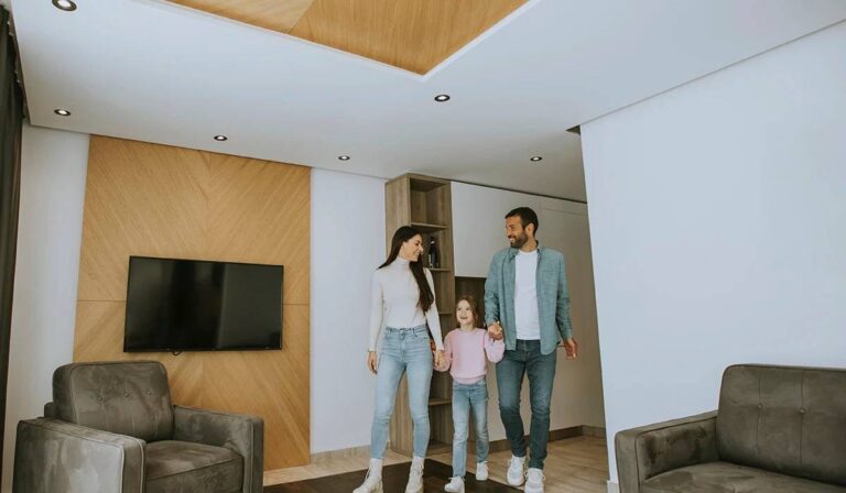 modern-living-room-interior-with-warm-design-and-a-family-of-three-walking-together-inside-the-space