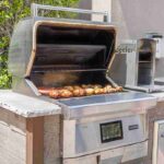 outdoor-seefer-brand-pellet-grill-which-appears-to-be-built-into-an-outdoor-kitchen-counter-and-the-grill-has-an-open-lid-revealing-food