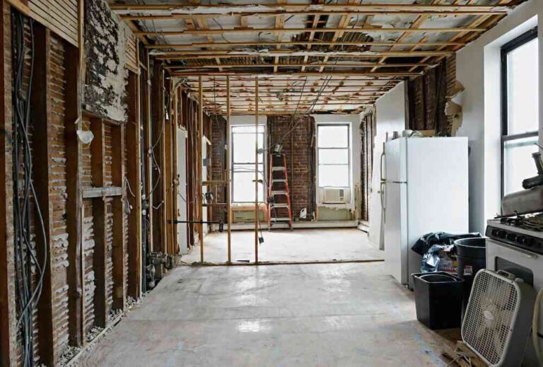 the-room-is-completely-gutted-with-wooden-wall-studs-and-ceiling-beams-the-insulation-and-wall-panel-have-been-removed-giving-unfinished-look