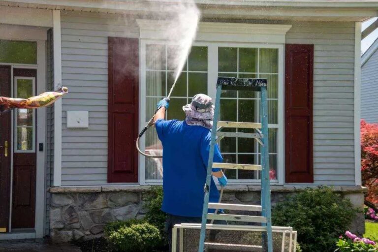Why We Recommend Window Cleaning After Pressure Washing Service a-person-pressure-washing-the-exterior-windows-of-a-residential-house