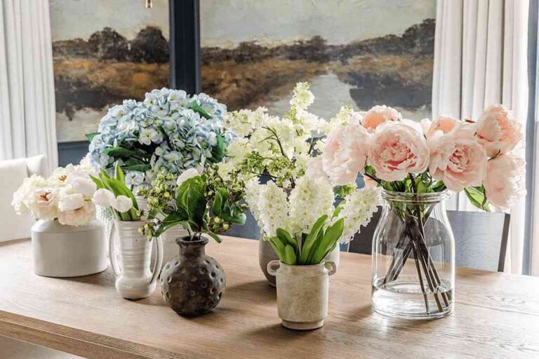 The Best Wholesale, Real-Touch Artificial Flowers for Every Room in Your House in 2026 artificial-floral-arrangements-displayed-in-various-vases-on-a-windowsill-the-selection-includes-faux-blue-hydranges-white-flowers-soft-pink-rose-etc