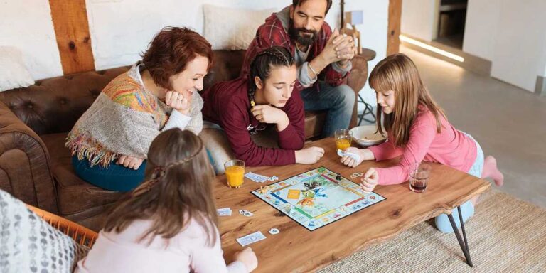 Planning a Games Night In to Avoid the Cold family-of-five-gathered-around-a-wooden-coffee-table-in-a-cozy-living-room-engaged-in-a-board-game