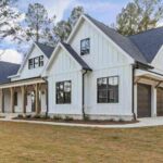 large-two-story-single-family-residence-with-white-siding-with-dark-trimmed-window-and-dark-roof