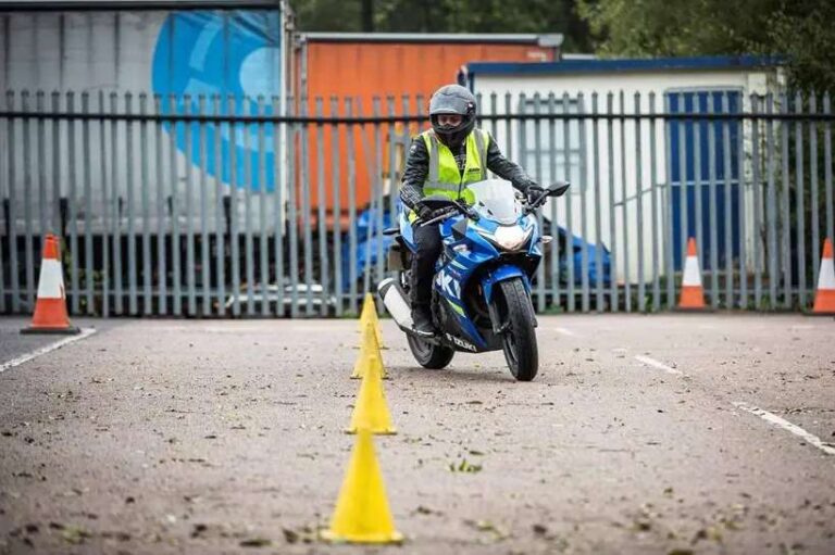 person-wearing-a-helmet-and-high-visibility-vest-actively-riding-a-motorcycyle-in-a-paved-fenced-area