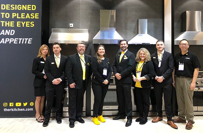 Top Kitchen Dealership Opportunities for Distributors & Showroom Owners team-of-professionals-likely-representatives-from-thor-kitchen-standing-in-front-of-a-row-of-stainless-steel-kitchen