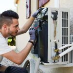 technician-installing-an-outdoor-air-conditioning-compressor-unit-and-it-is-mounted-on-a-wall-bracket