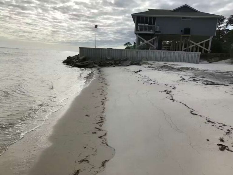 the-foreground-is-dominated-by-a-sandy-beach-with-a-wet-drk-line-where-the-water-is-receded-the-ocean-water-is-visible-to-left