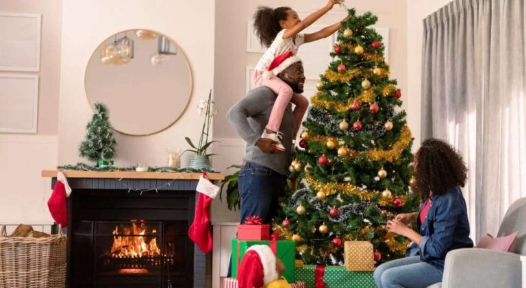warm-festive-scene-of-a-family-decorating-for-the-holidays-in-their-living-room-a-man-is-holding-a-young-girl-so-she-can-reach-the-top-of-the-tree