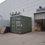 10-foot-shipping-container-positioned-next-to-a-warehouse-or-industrial-building