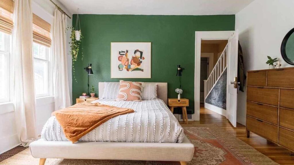 An Image of Bedroom Painted with off White and Green Accent Wall