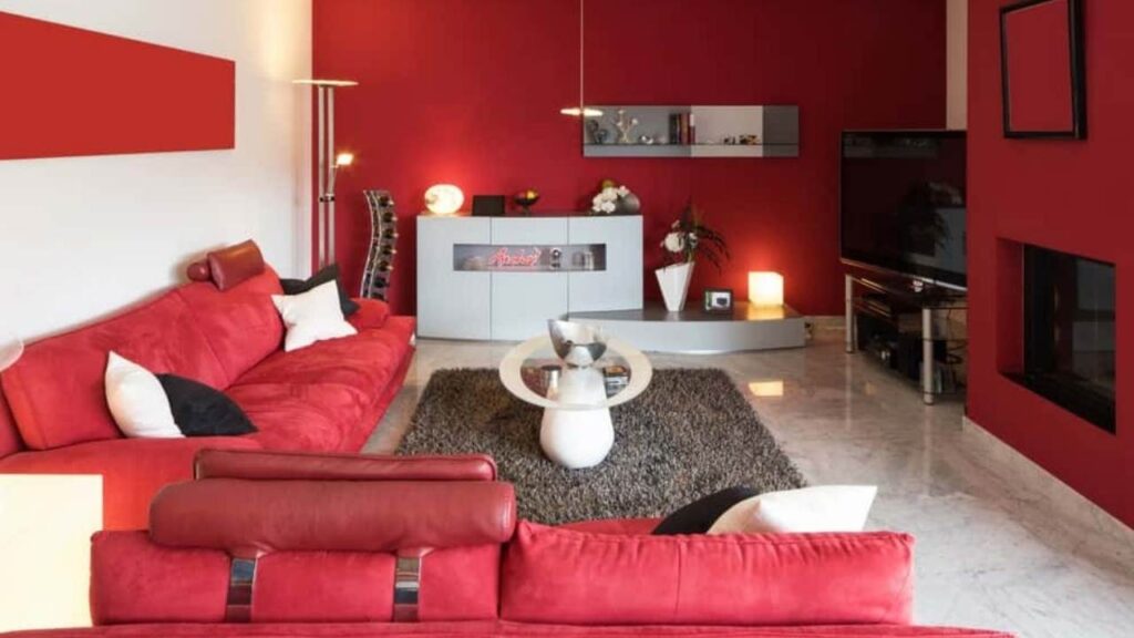 An Image of Living room Painted with off White And Red Accent wall 