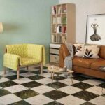 a-contemporary-living-room-design-featuring-a-bold-black-and-white-checkered-floor-and-tan-leather-sofa-is-paired-with-light-green-armchair