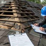 a-man-holding-a-clipboard-and-pen-appearing-to-take-notes-or-fill-out-a-report-likely-for-an-insurance-claim-or-repair-estimate