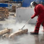 a-man-performing-high-pressure-water-jetting-this-cleaning-process-uses-powerful-water-streams-to-remove-paint-etc