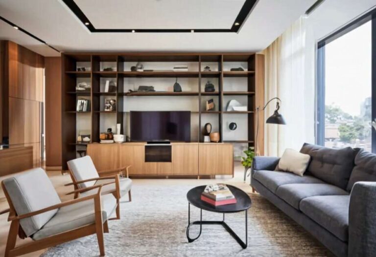 a-modern-minimalist-living-room-designed-for-maximizing-storage-and-features-a-light-colored-low-profile-sofa-on-the-right-of-two-modern-wood-framed-armchair