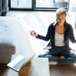 a-women-is-seated-in-a-cross-legged-lotus-position-on-a-light-colored-rug-she-is-practicing-a-yoga