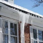 house-with-severe-ice-damming-on-its-roof-characterized-by-thick-ridges-of-ice-and-large-icicles-hanging-from-the-eaves