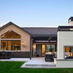 modern-outdoor-living-and-kitchen-area-and-the-home-features-a-mix-of-texture-including-clean-white-stucco-dark-siding-and-large-glass-windows