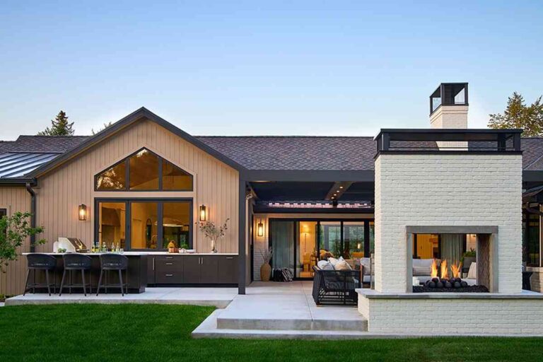 modern-outdoor-living-and-kitchen-area-and-the-home-features-a-mix-of-texture-including-clean-white-stucco-dark-siding-and-large-glass-windows