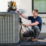 professional-HVAC-technician-performing-maintenance-or-a-repair-on-a-modern-outdoor-air-conditioning-condenser-unit