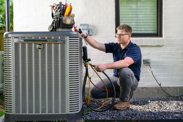 professional-HVAC-technician-performing-maintenance-or-a-repair-on-a-modern-outdoor-air-conditioning-condenser-unit