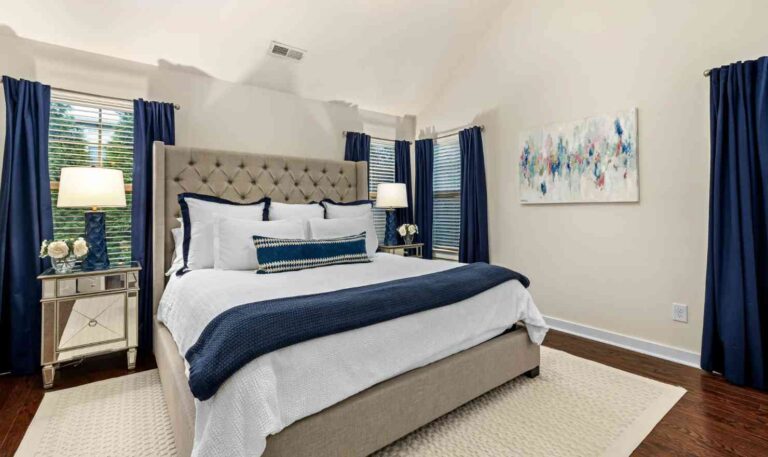 small-bedroom-design-centered-around-a-queen-size-bed-the-room-features-neutral-color-palette-with-bold-navy-blue-accents-seen-in-the-floor