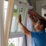 technician-professionally-installing-a-new-white-window-frame-into-a-homes-rough-opening