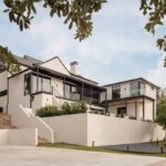 the-home-features-multi-level-design-with-white-exterior-walls-and-dark-framed-windows-that-offer-expansive-views