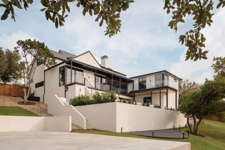 the-home-features-multi-level-design-with-white-exterior-walls-and-dark-framed-windows-that-offer-expansive-views