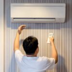 a-person-performing-DIY-maintenance-on-a-wall-mounted-mini-split-air-conditioning-unit