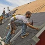 group-of-roofing-contractors-working-on-a-residential-rooftop-and-also-wearing-a-tool-belt-loaded-with-supplies